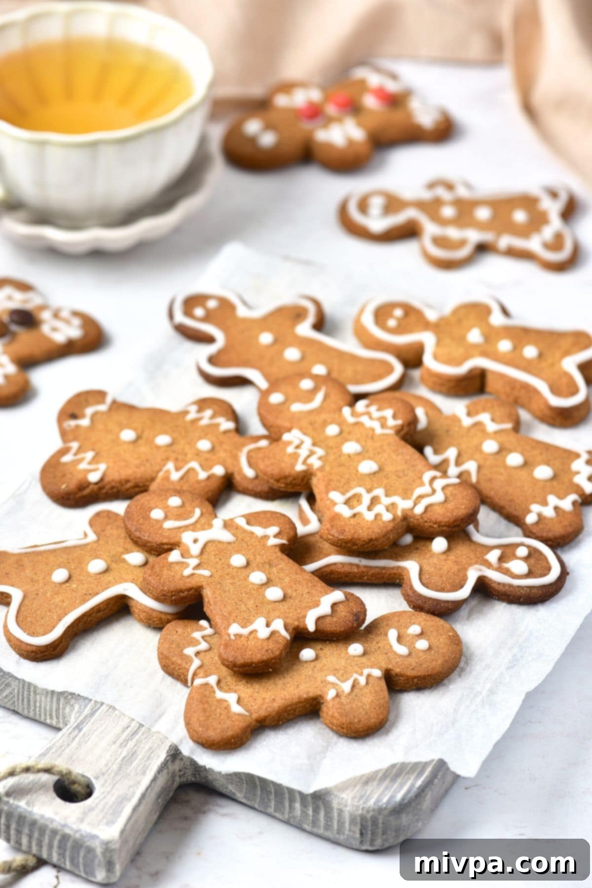 Gluten-Free Gingerbread Men Cookies (Dairy-Free) Gluten-free gingerbread men cookies on parchment-lined board, ready for decorating.