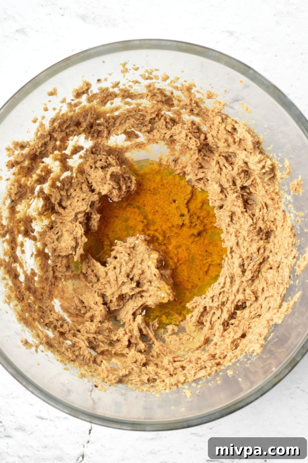 Gluten Dairy-Free Gingerbread Men Golden maple syrup being added to the center of the butter-sugar mixture, ready to be blended.
