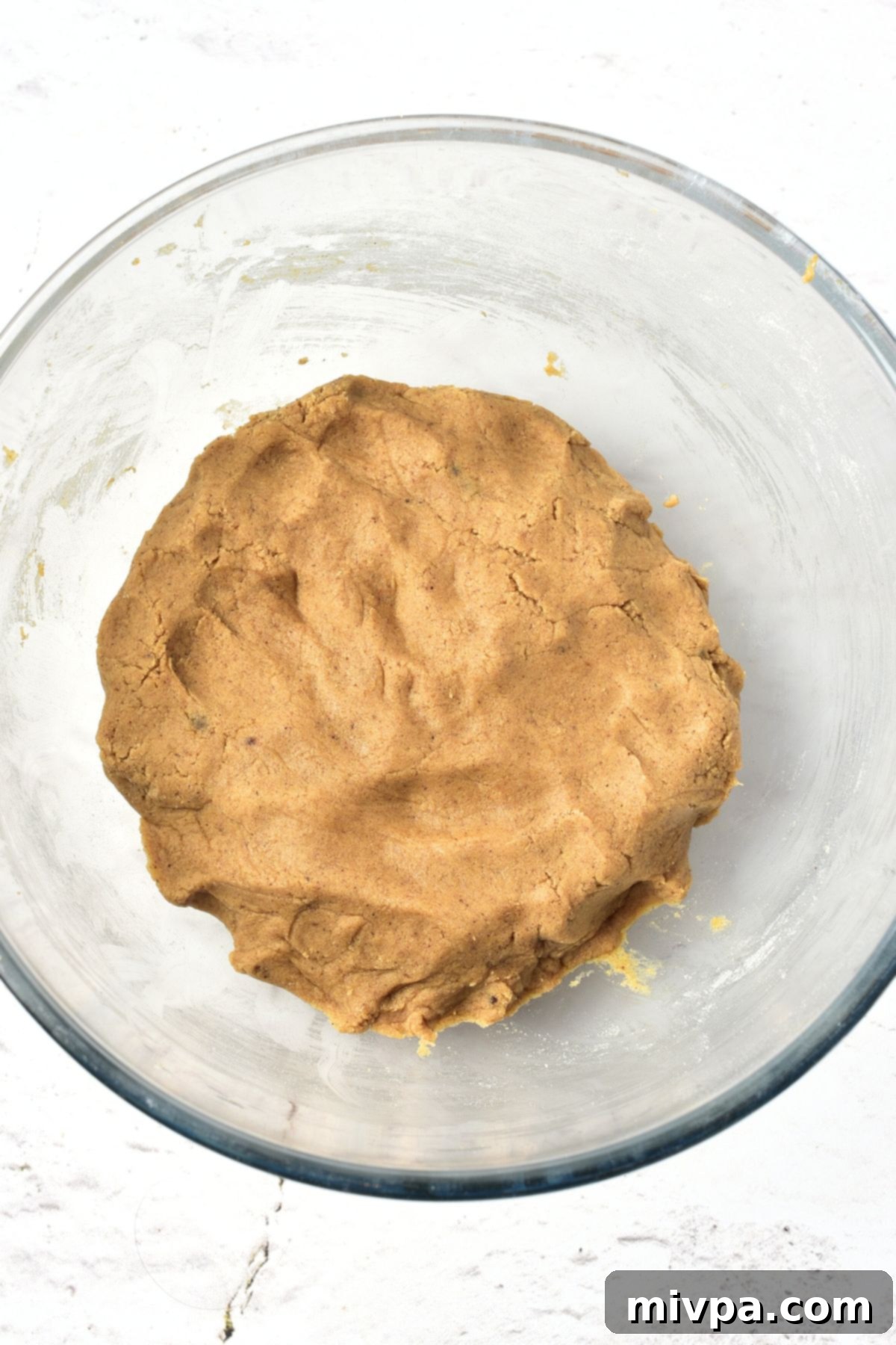 Easy Gluten-Free Gingerbread Men Cookies (Dairy-Free) Cookie dough in glass bowl, showcasing its soft and uniform consistency.
