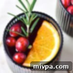 Simple Homemade Mulled Wine Gluten-Free and Vegan 10 A glass of homemade mulled wine with an orange slice, cranberries, and a sprig of rosemary for garnish.
