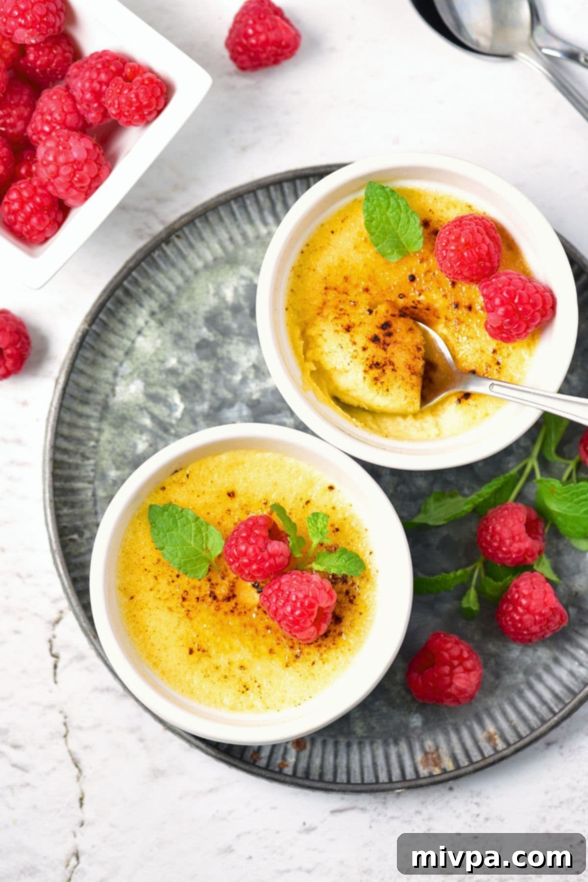 Close-up of a single serving of crème brûlée in a ramekin, showing the smooth, light yellow custard and the distinct, golden-brown caramelized sugar crust.