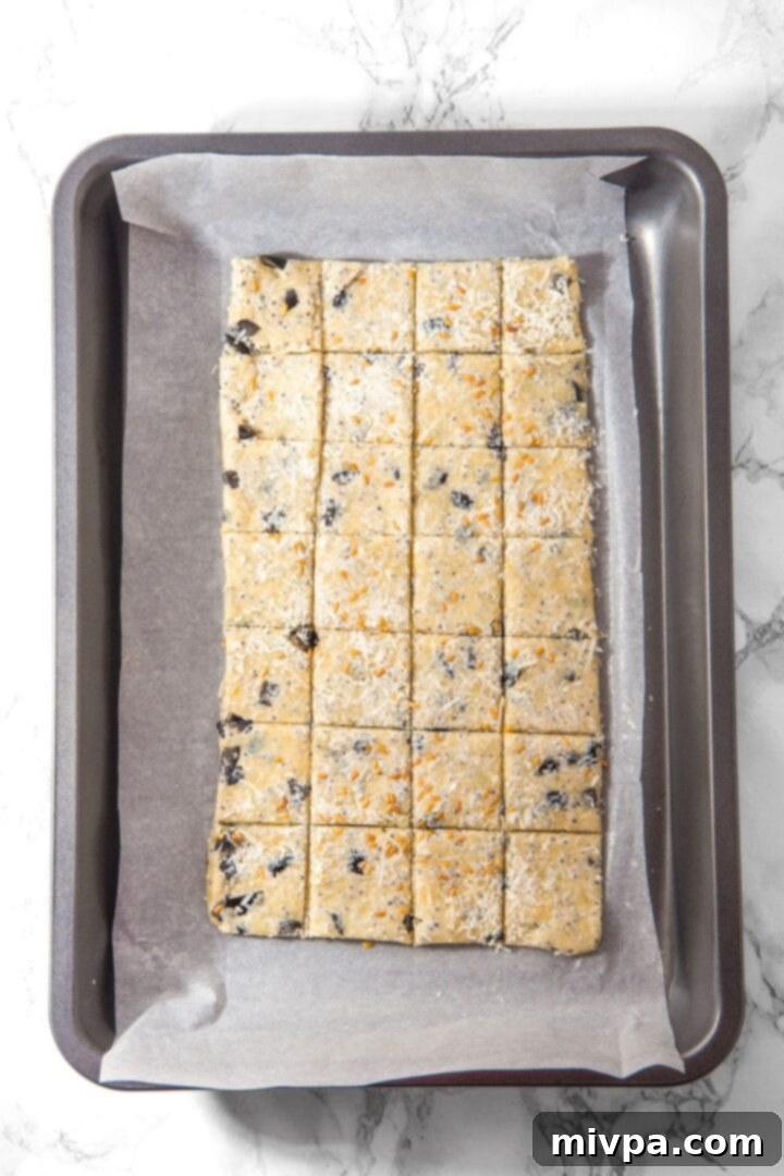 Easy Almond Flour Cracker Recipe Sliced cracker dough on parchment-lined baking sheet