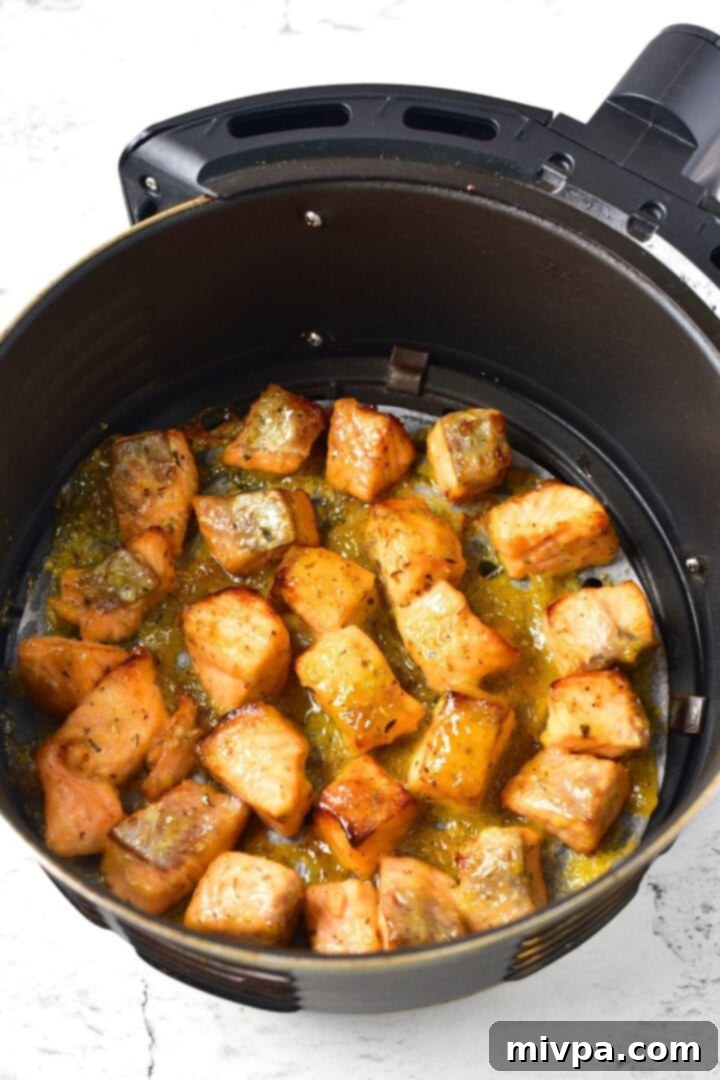 Air fried salmon pieces in air fryer basket