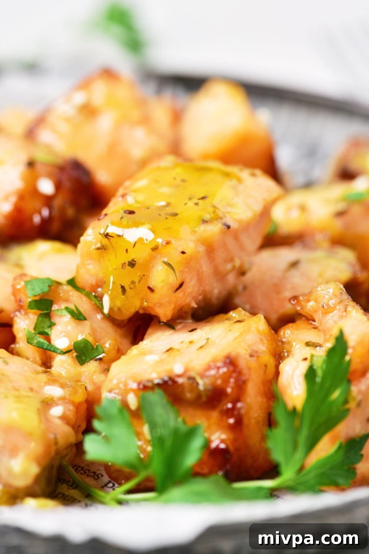 Up close view of a plate of air fryer honey mustard salmon bites.