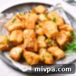 Air fryer salmon bites on a parchment-lined plate.