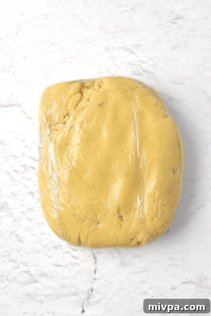Cookie dough wrapped in plastic wrap, chilling in the refrigerator.