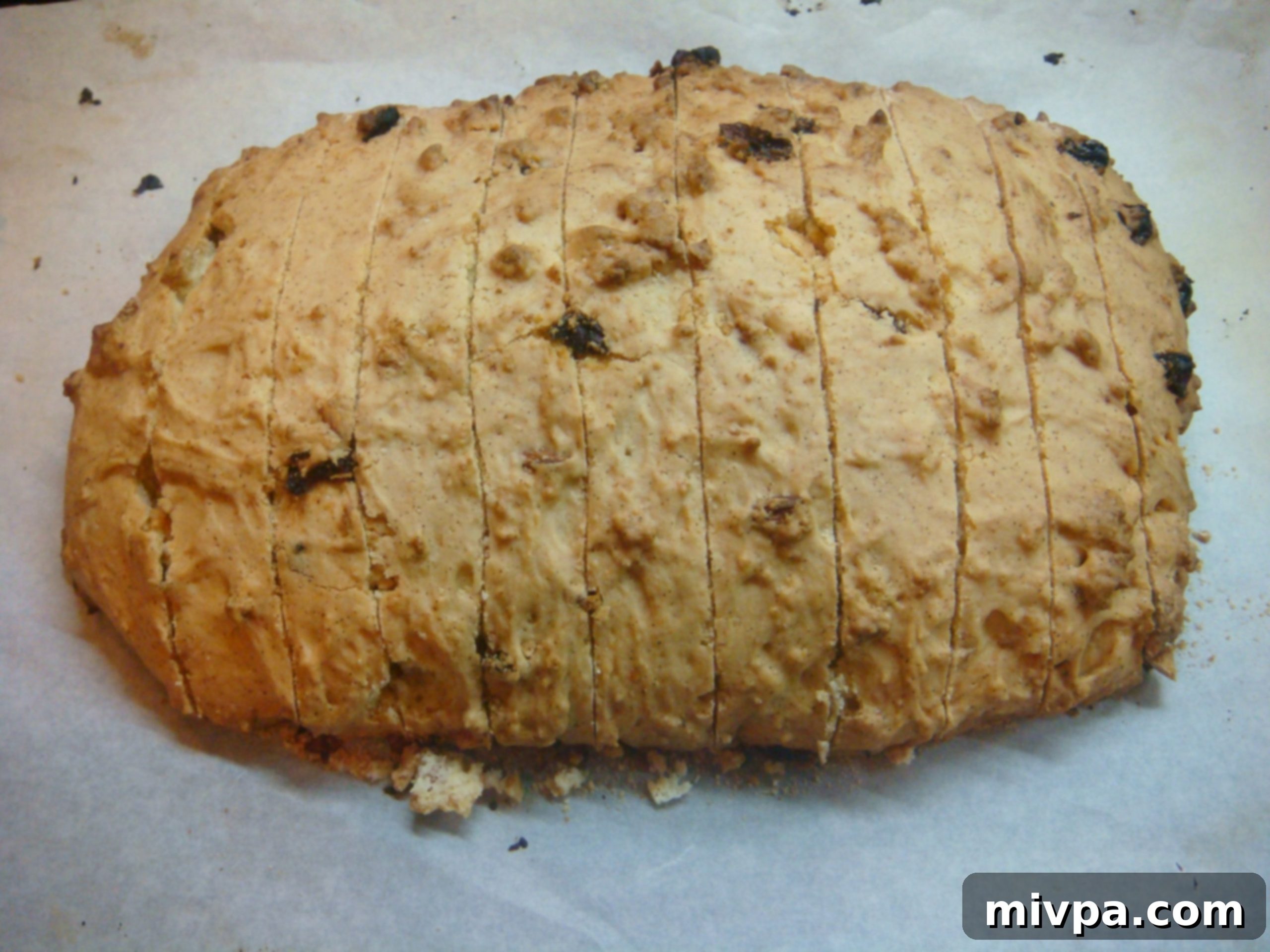 Zesty Lemon Almond Raisin Biscotti 15 Using a serrated knife to carefully slice the warm biscotti log diagonally into individual pieces, creating their characteristic oblong shape.