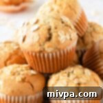 Easy Gluten-Free Dairy-Free Oatmeal Muffins 2 A stack of golden-brown gluten-free oatmeal muffins, showcasing their texture and wholesome appeal.