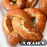 Up close shot of gluten-free soft pretzels with coarse salt, showcasing their perfect texture and golden hue.
