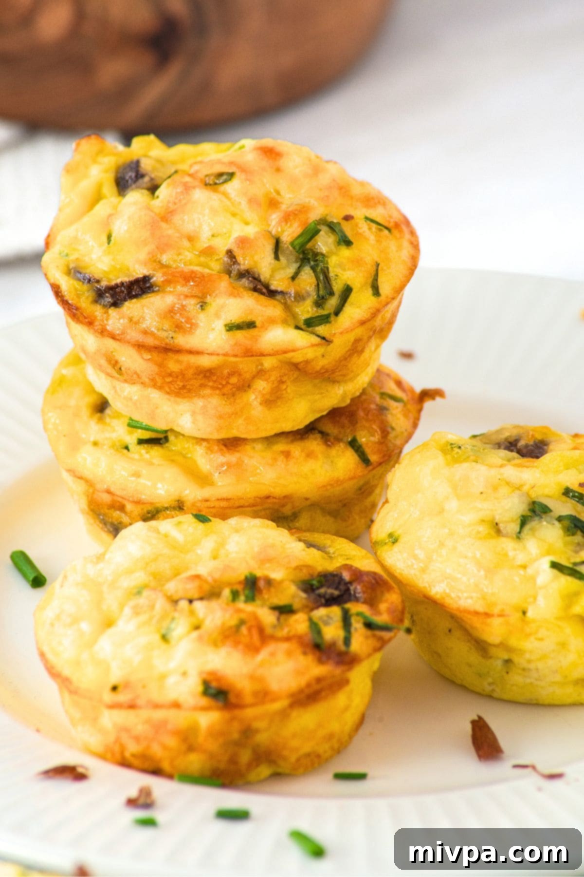 Cottage Cheese Egg Muffins (Gluten-Free) A beautifully arranged stack of golden-brown cottage cheese egg muffins on a white plate, ready for serving.