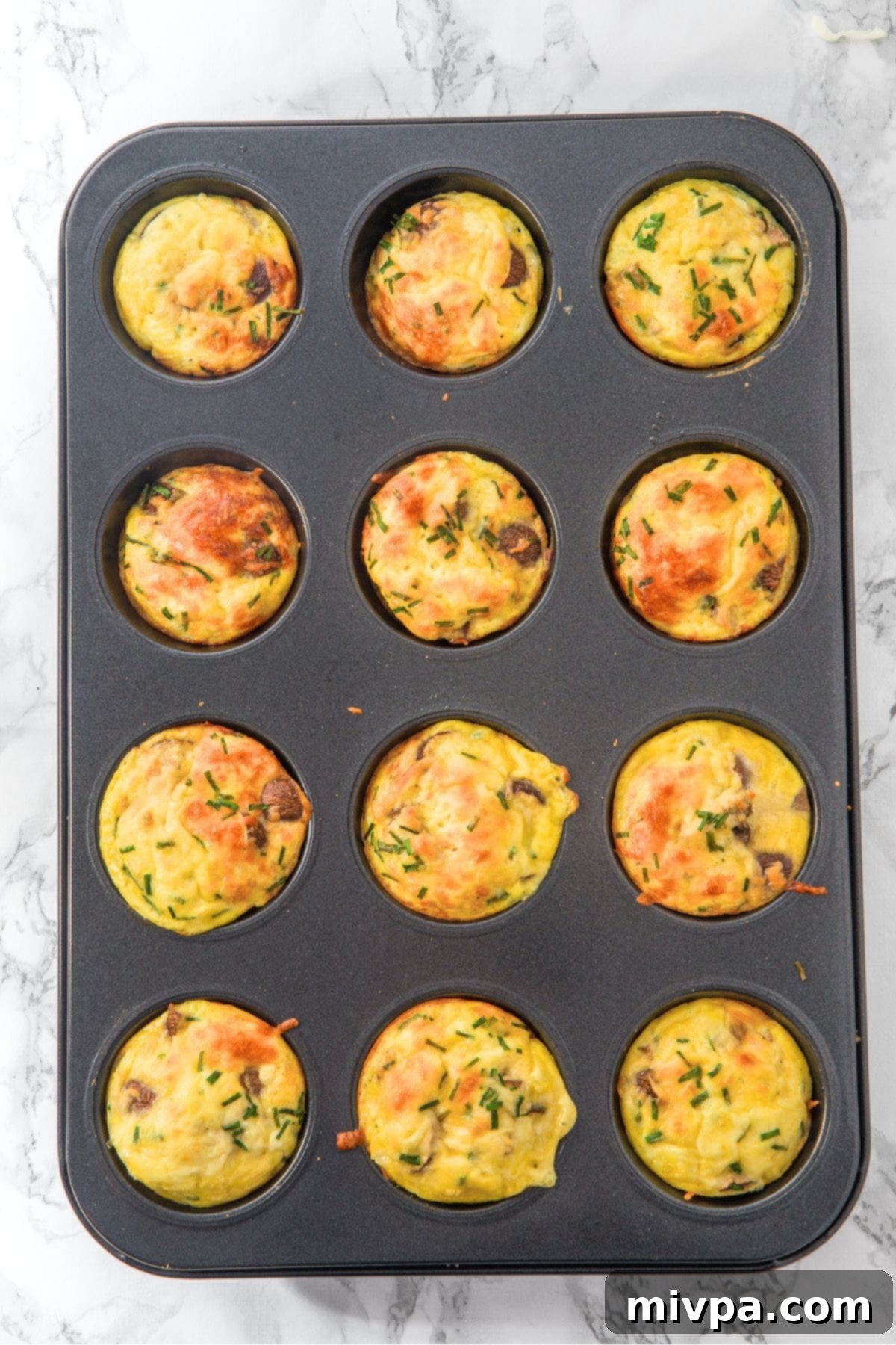Cottage Cheese Egg Muffins (Gluten-Free) A batch of freshly baked cottage cheese egg muffins, golden brown and perfectly puffed, still in the muffin tin.