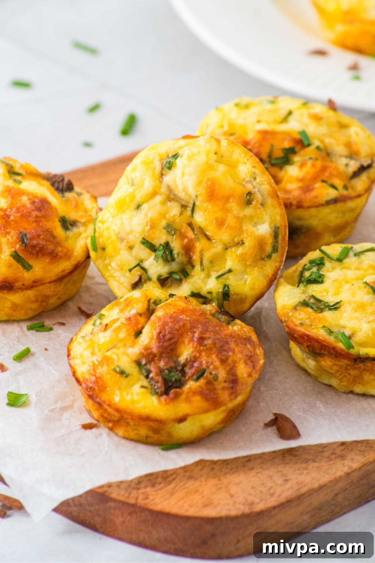 Savory Gluten-Free Breakfast Muffins A vibrant display of savory gluten-free breakfast muffins, neatly arranged on a parchment-lined wooden board.