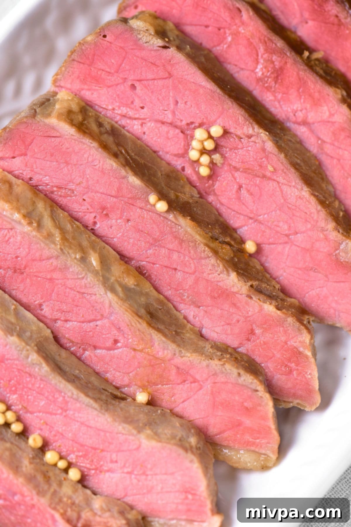 Up close view of slices of slow cooker corned beef brisket, showcasing its tender texture and rich color.