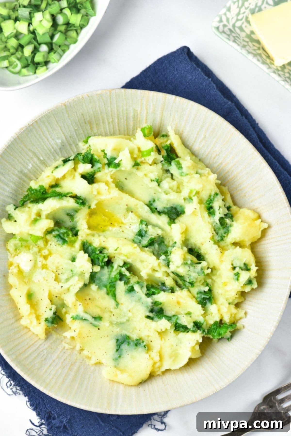 Colcannon (Irish Mashed Potatoes) with Kale Top down view of a large bowl of colcannon (Irish mashed potatoes) garnished with fresh herbs
