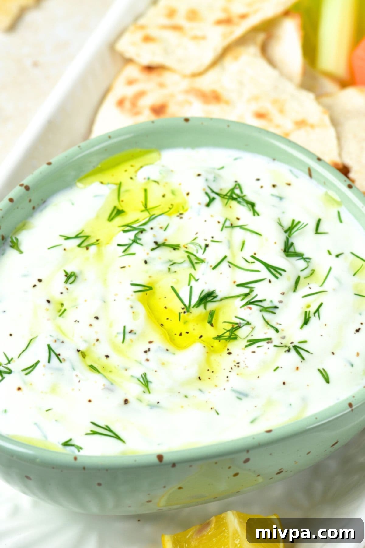 A bowl of dairy-free Greek tzatziki with fresh dill garnish, ready to be enjoyed.