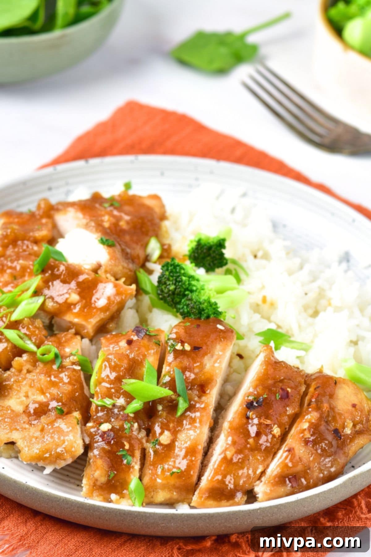 Gluten-Free Honey Garlic Chicken (Dairy-Free) Up close view of a plate of gluten-free honey and garlic chicken, highlighting the sticky sauce.