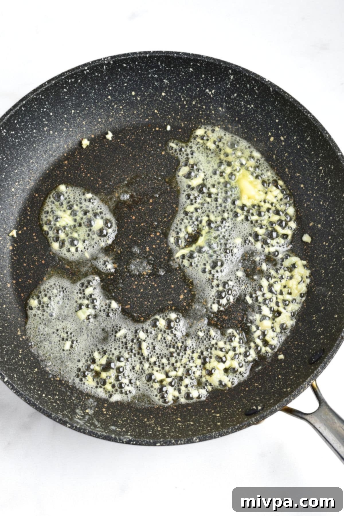 Garlic Honey Chicken Recipe Sautéing minced garlic in skillet until fragrant.