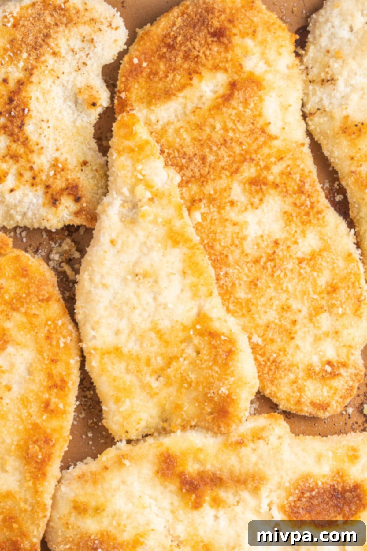 Up close view of golden-brown gluten-free breaded chicken cutlets ready to be served, highlighting their crispy texture and delicious appeal.