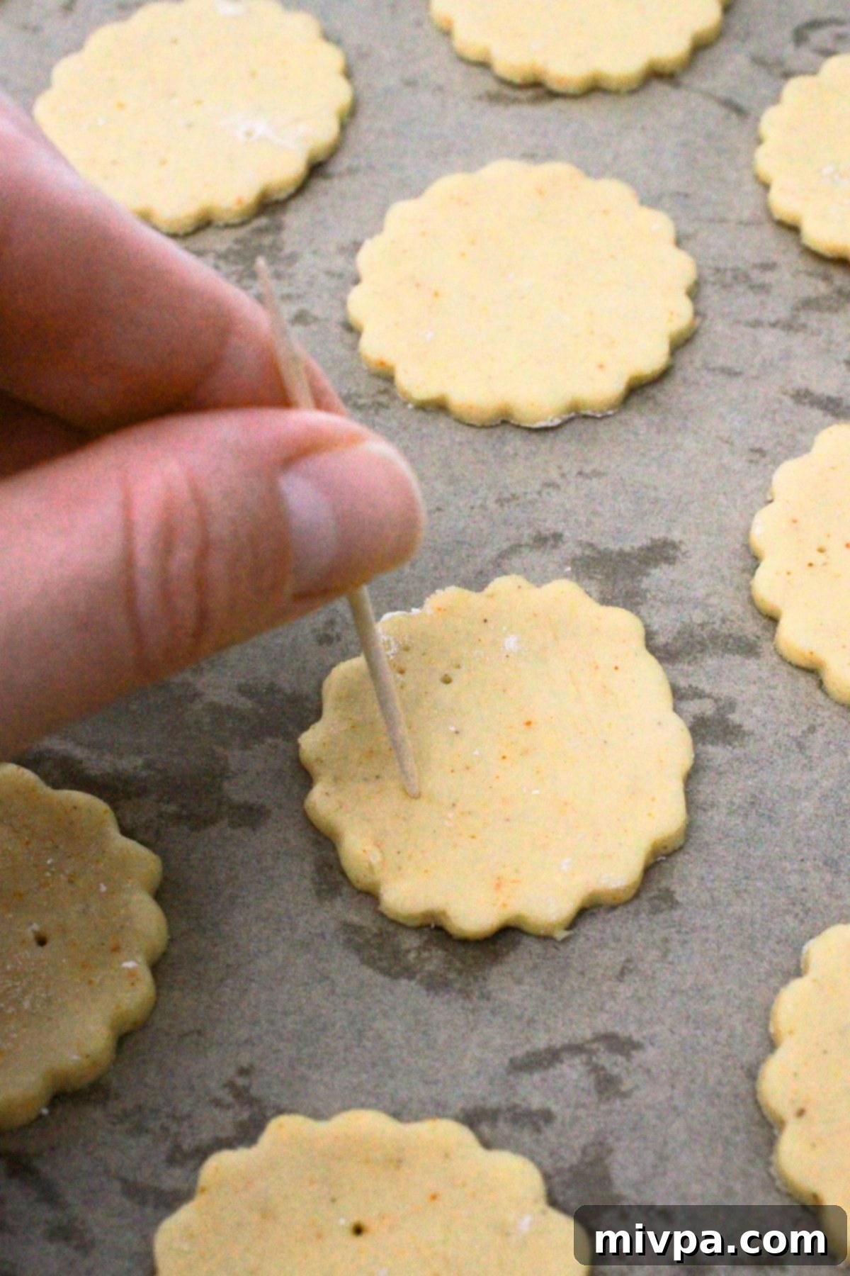 Homemade Gluten-Free Ritz Crackers Using toothpick to poke holes into cracker dough