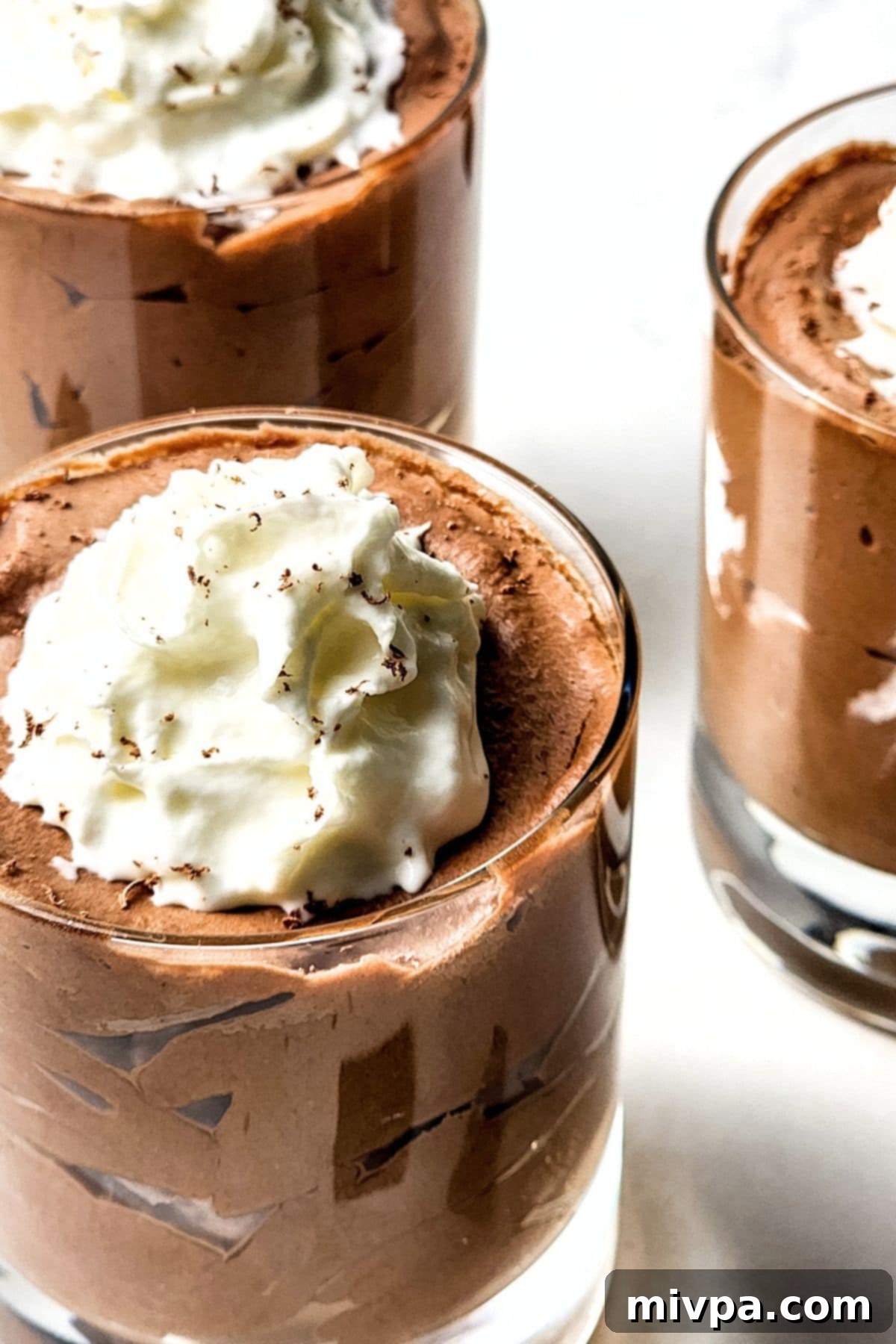 Glasses of chocolate mousse topped with whipped cream