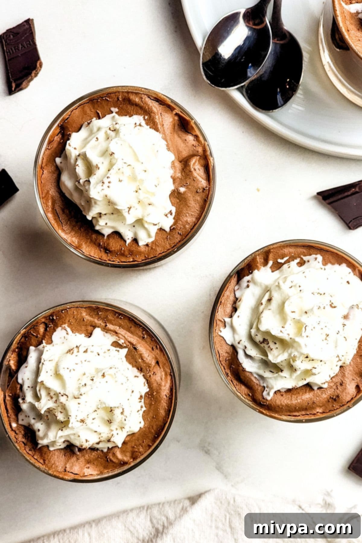 Top down view of glasses of chocolate mousse with whipped cream