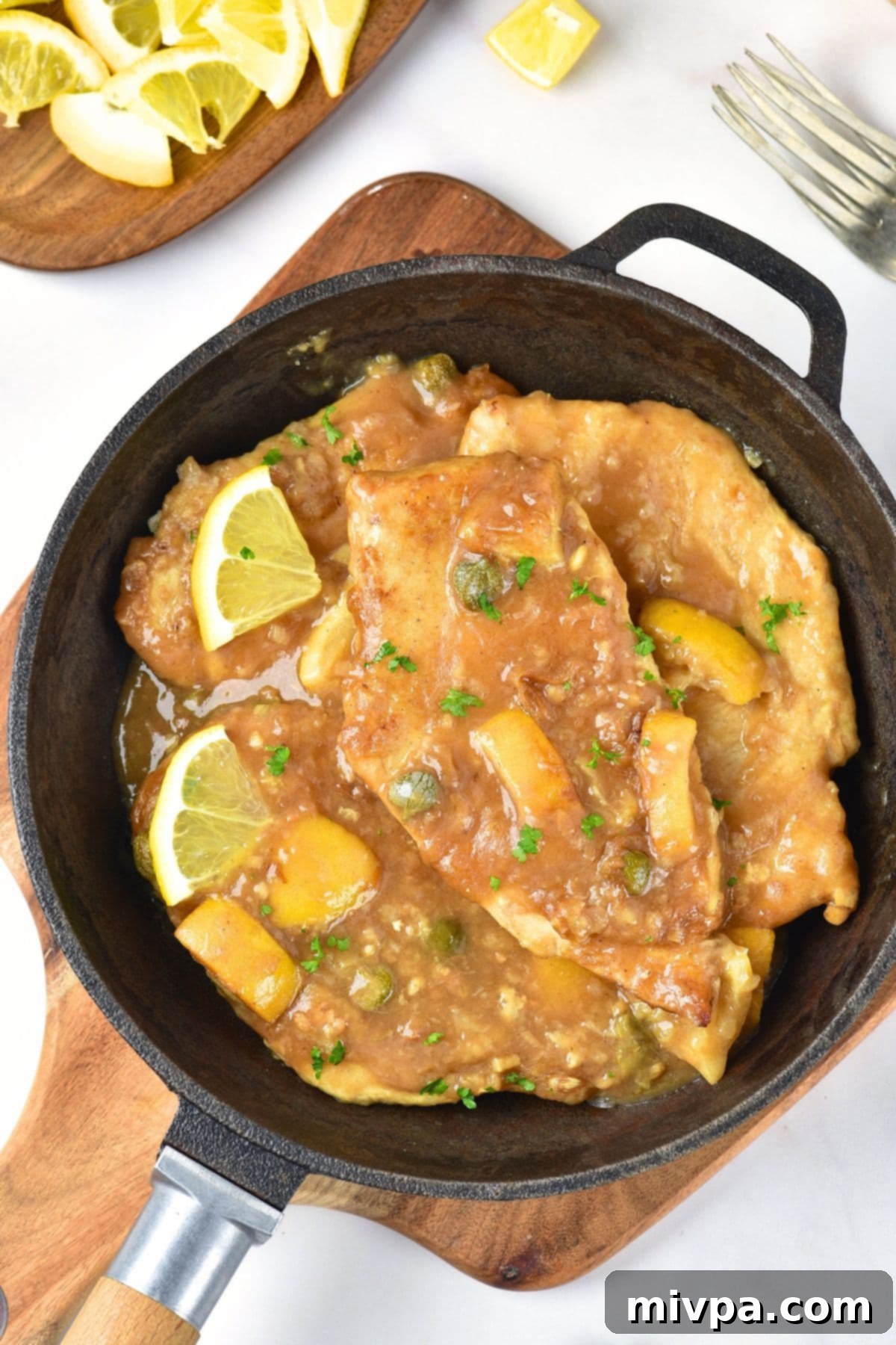 Top down view of gluten-free chicken piccata in a skillet.