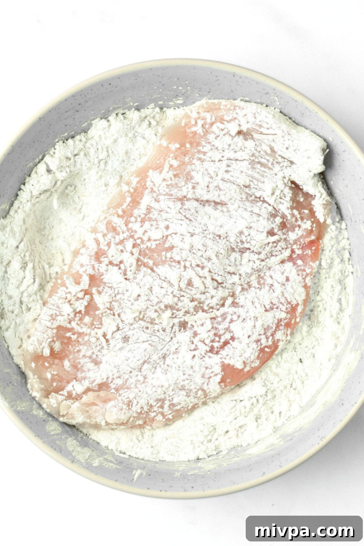 Coating chicken cutlet in flour mixture