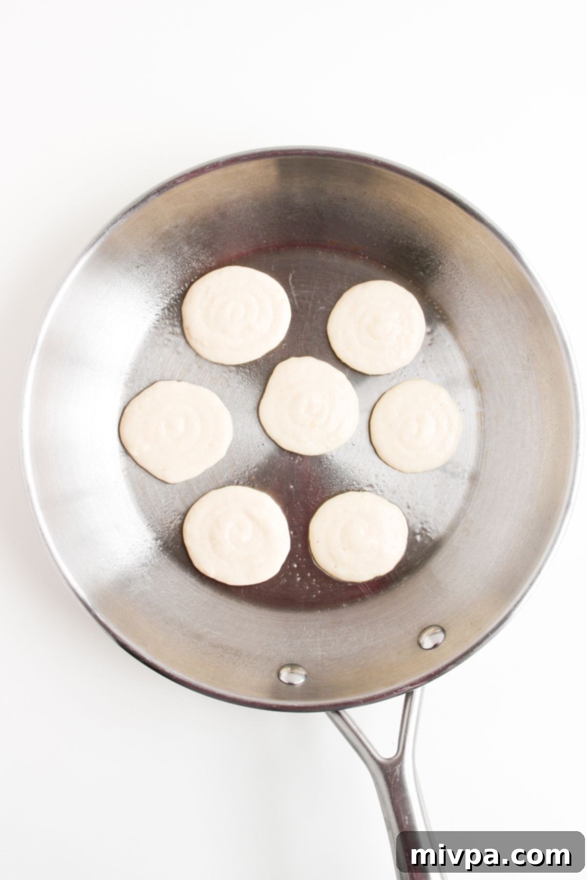 Cooking mini pancakes in skillet