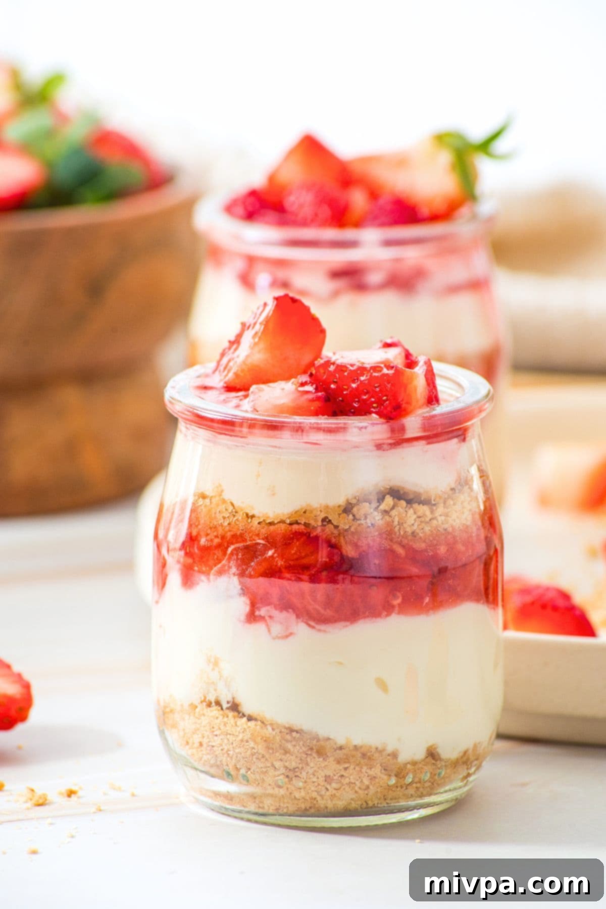 Strawberry Cheesecake Cups (Gluten-Free, No-Bake) Up close view of strawberry cheesecake cups on marble board.