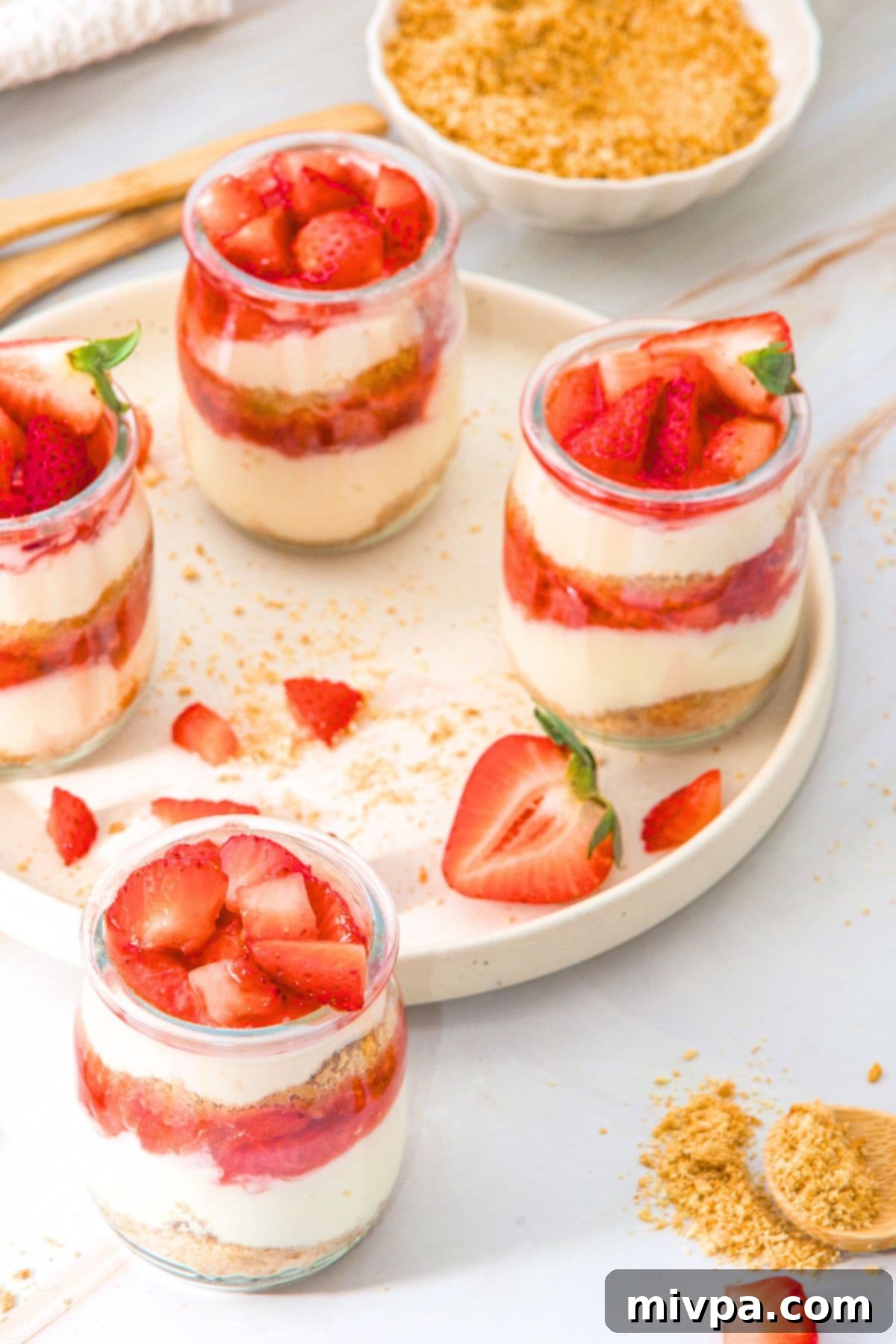 No-Bake Strawberry Cheesecake Cups (Gluten-Free) Multiple jars of no-bake strawberry cheesecake cups.