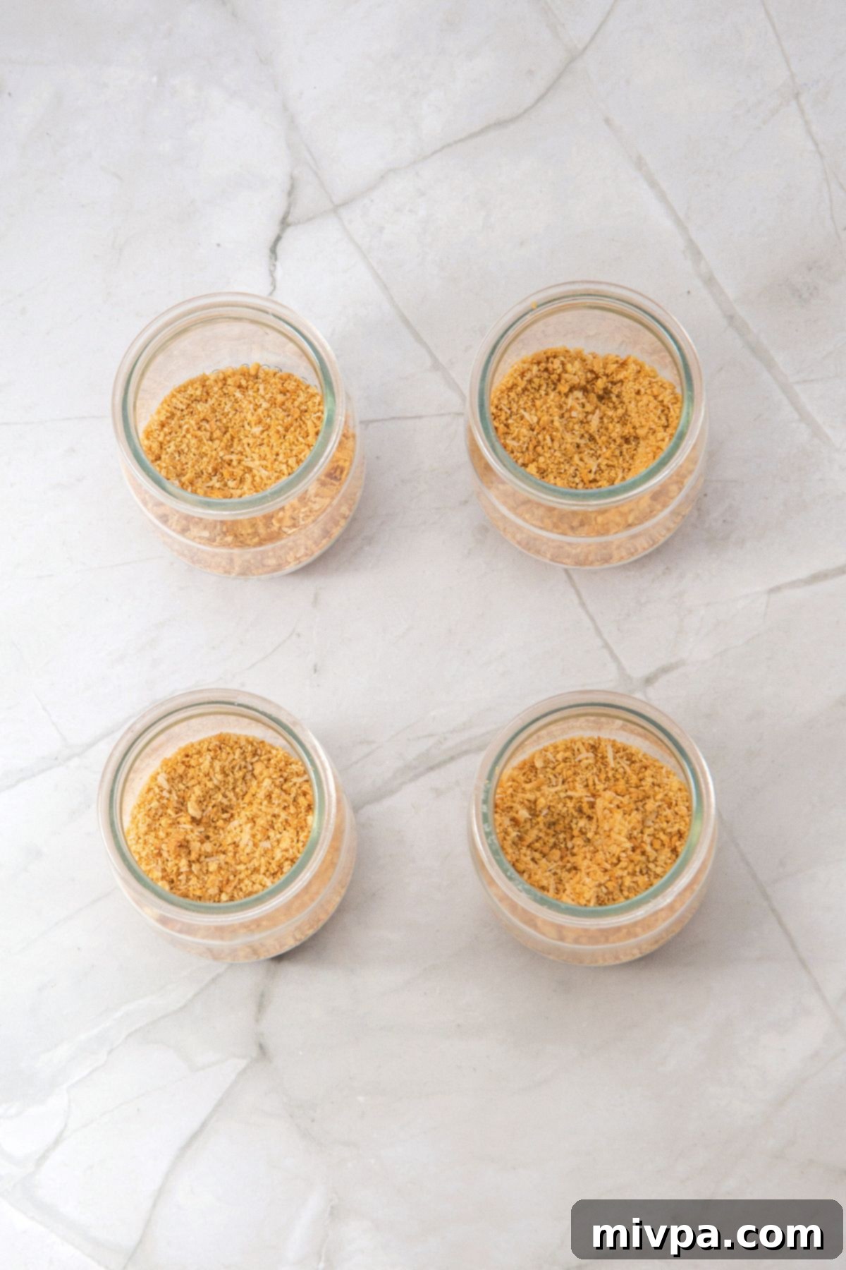 No-Bake Strawberry Cheesecake Cups Graham cracker crumbs in glass jars