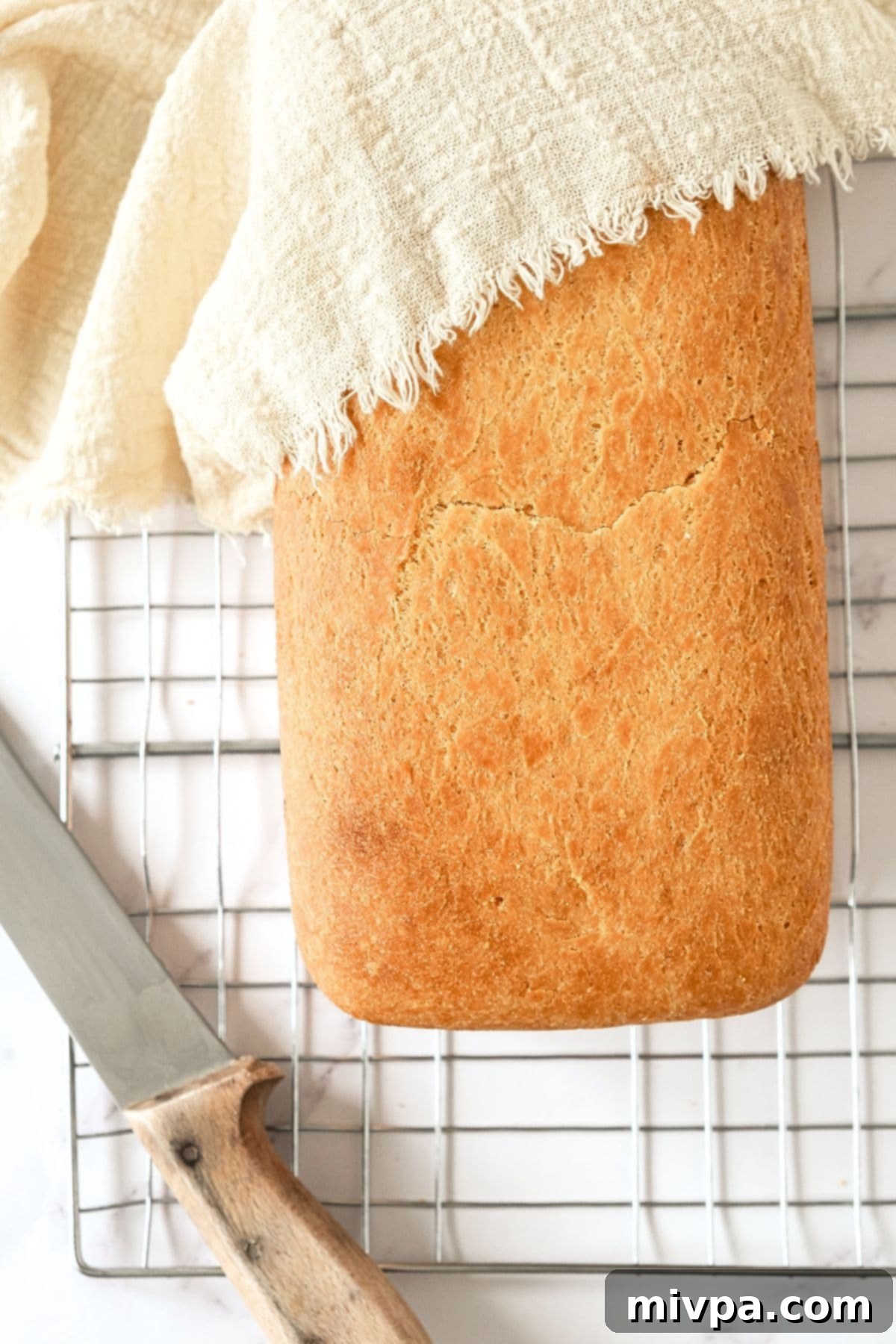 Freshly baked gluten egg-free bread on wire rack.