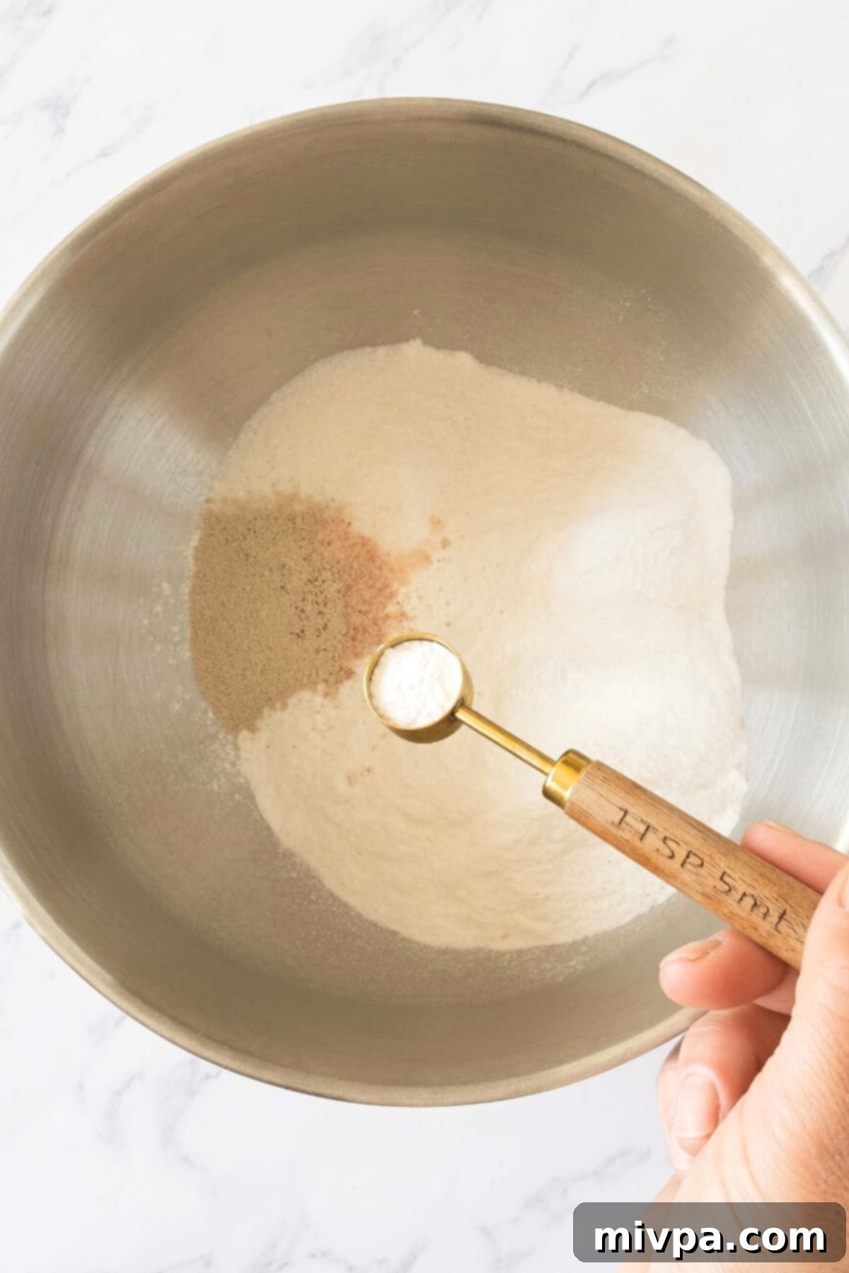 Mixing dry ingredients in metal bowl.
