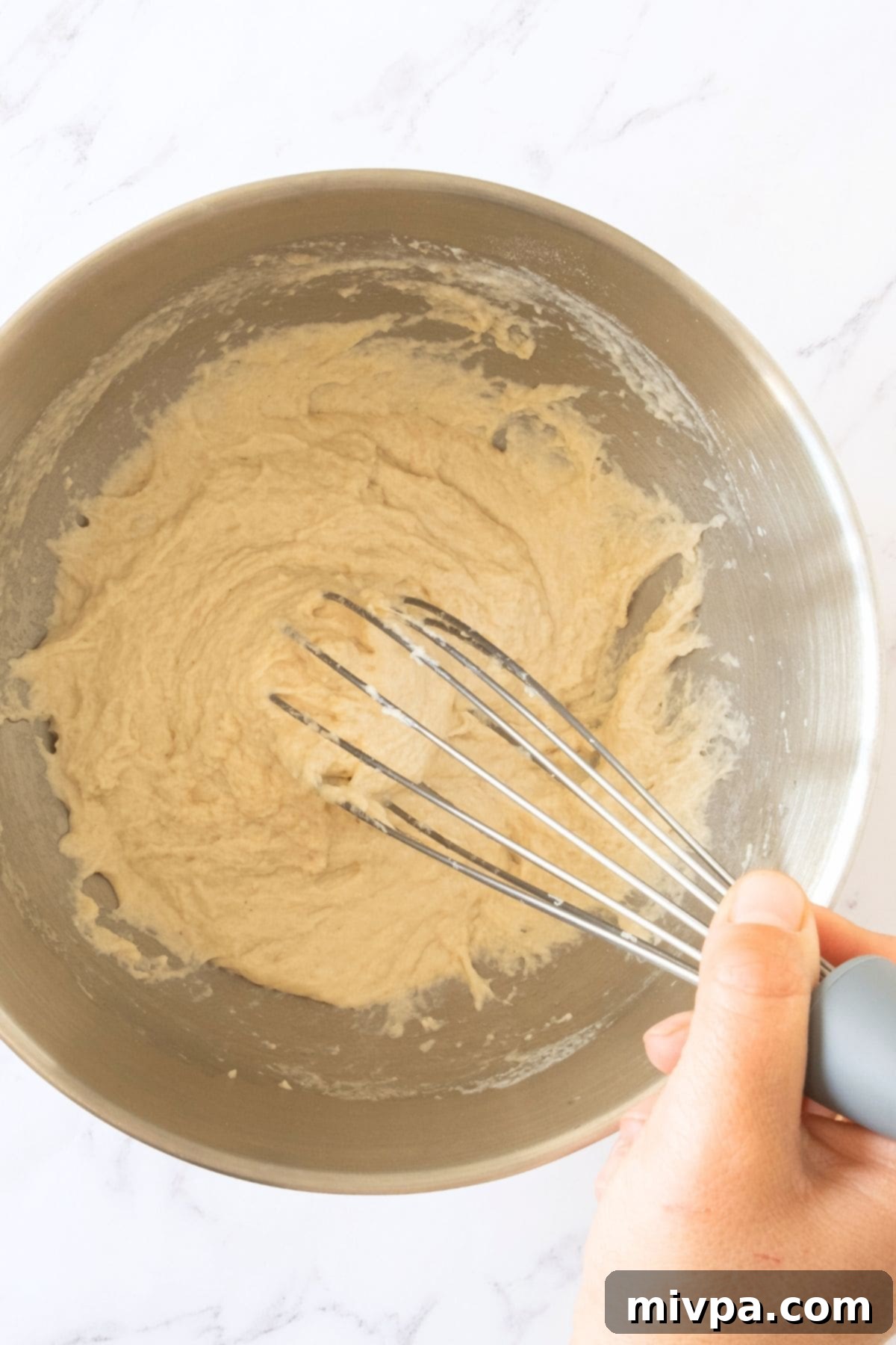 Mixing gluten-free bread dough with whisk.