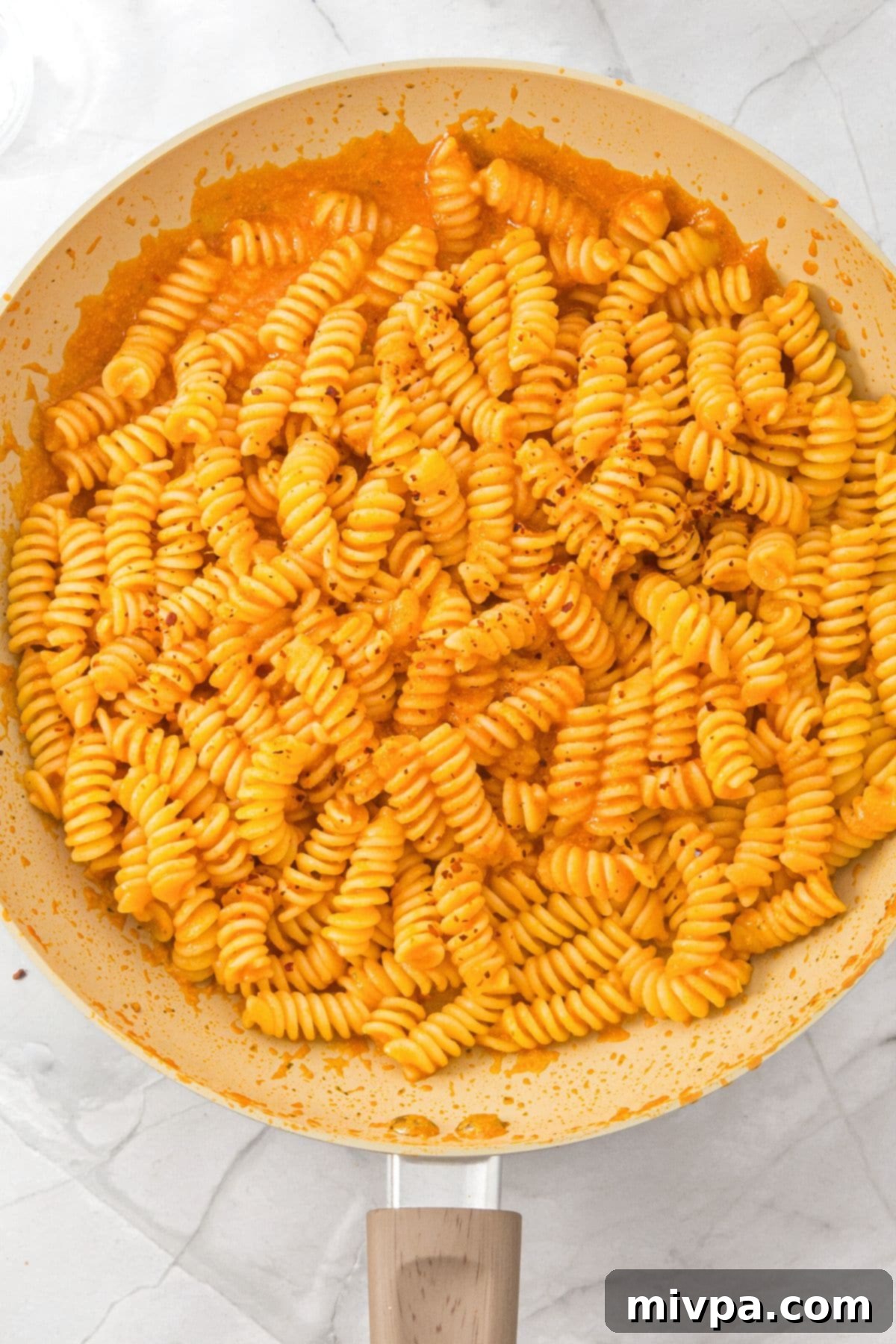 A skillet with fusilli pasta with cottage cheese sauce