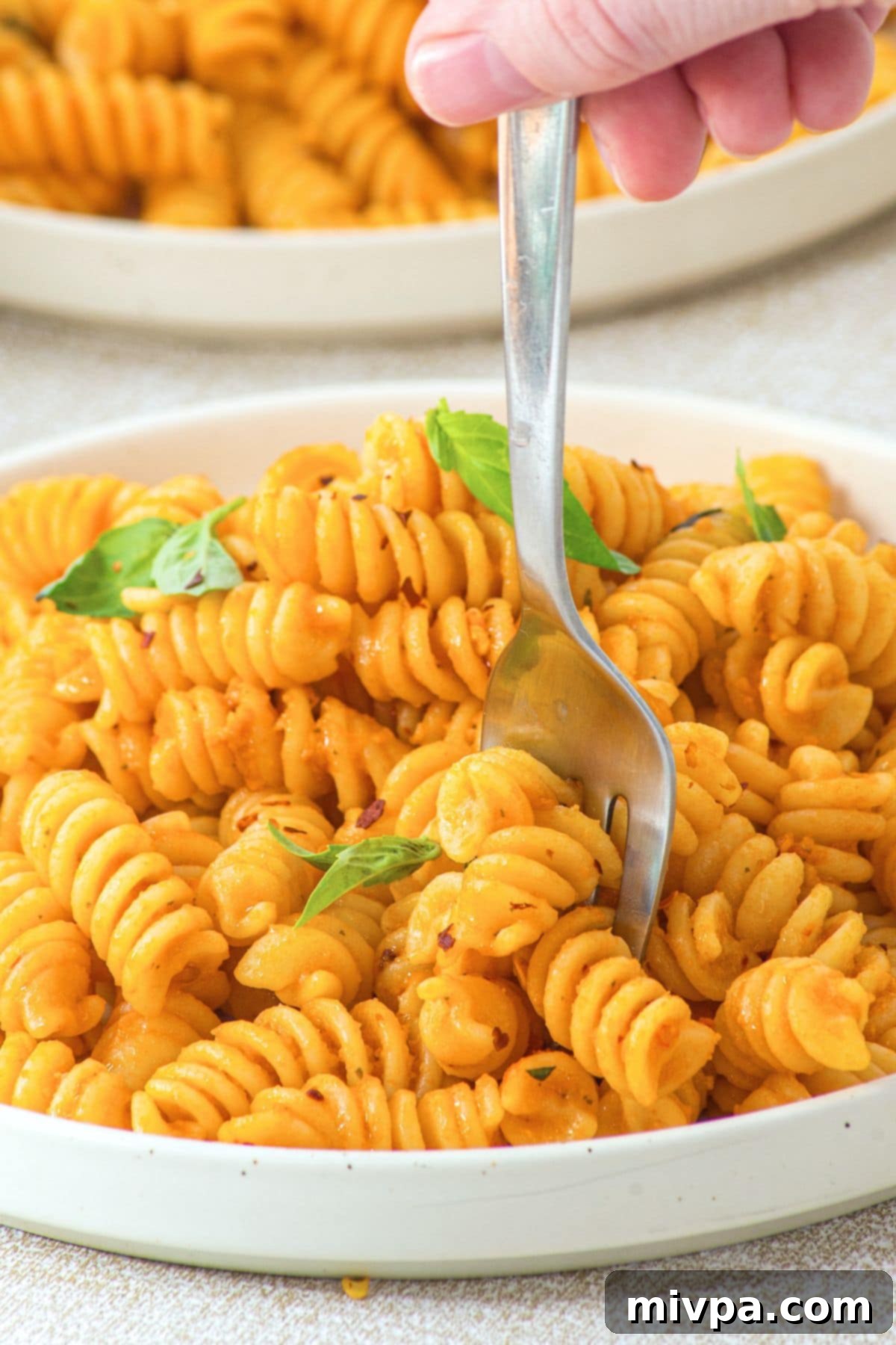 Holding up forkful of pasta with cottage cheese tomato pasta sauce.