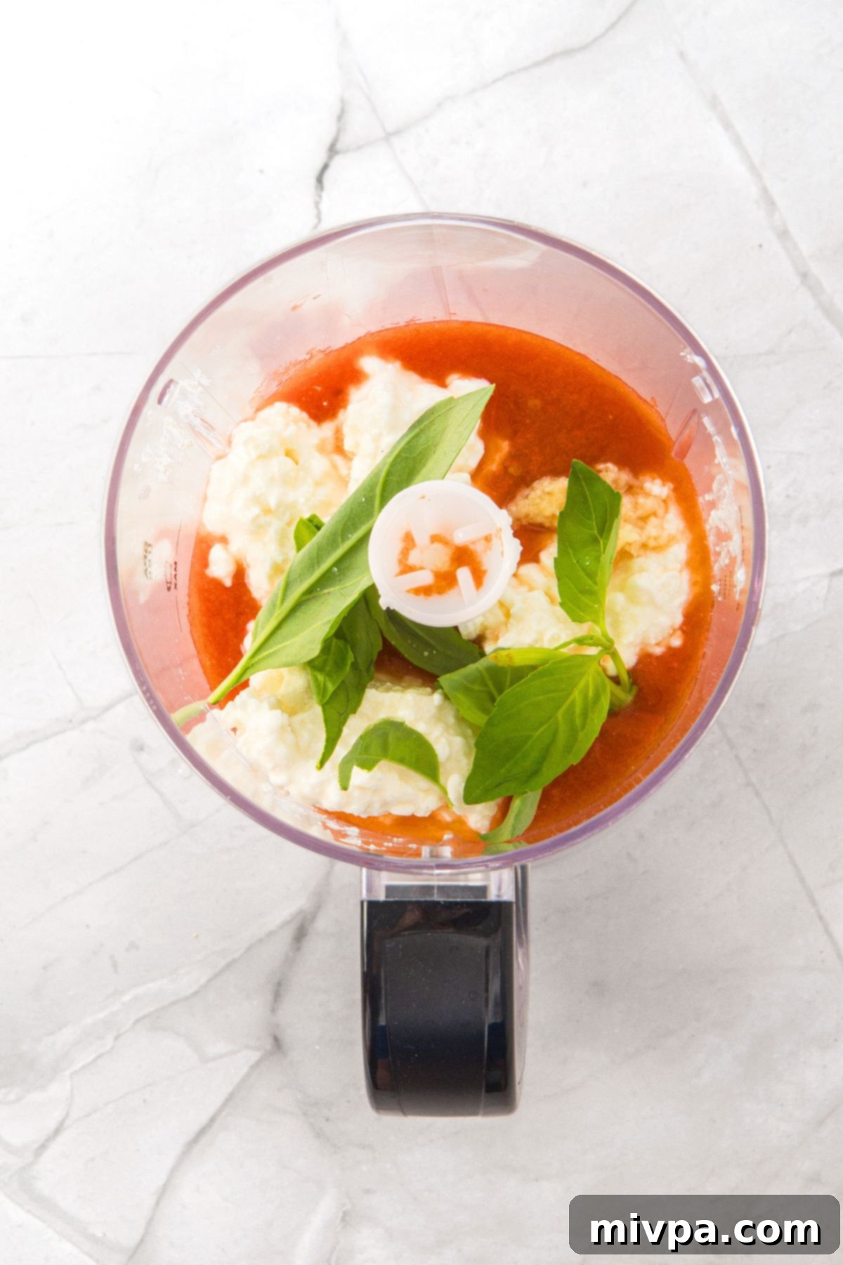 Cottage cheese, marinara sauce, and basil leaves in food processor