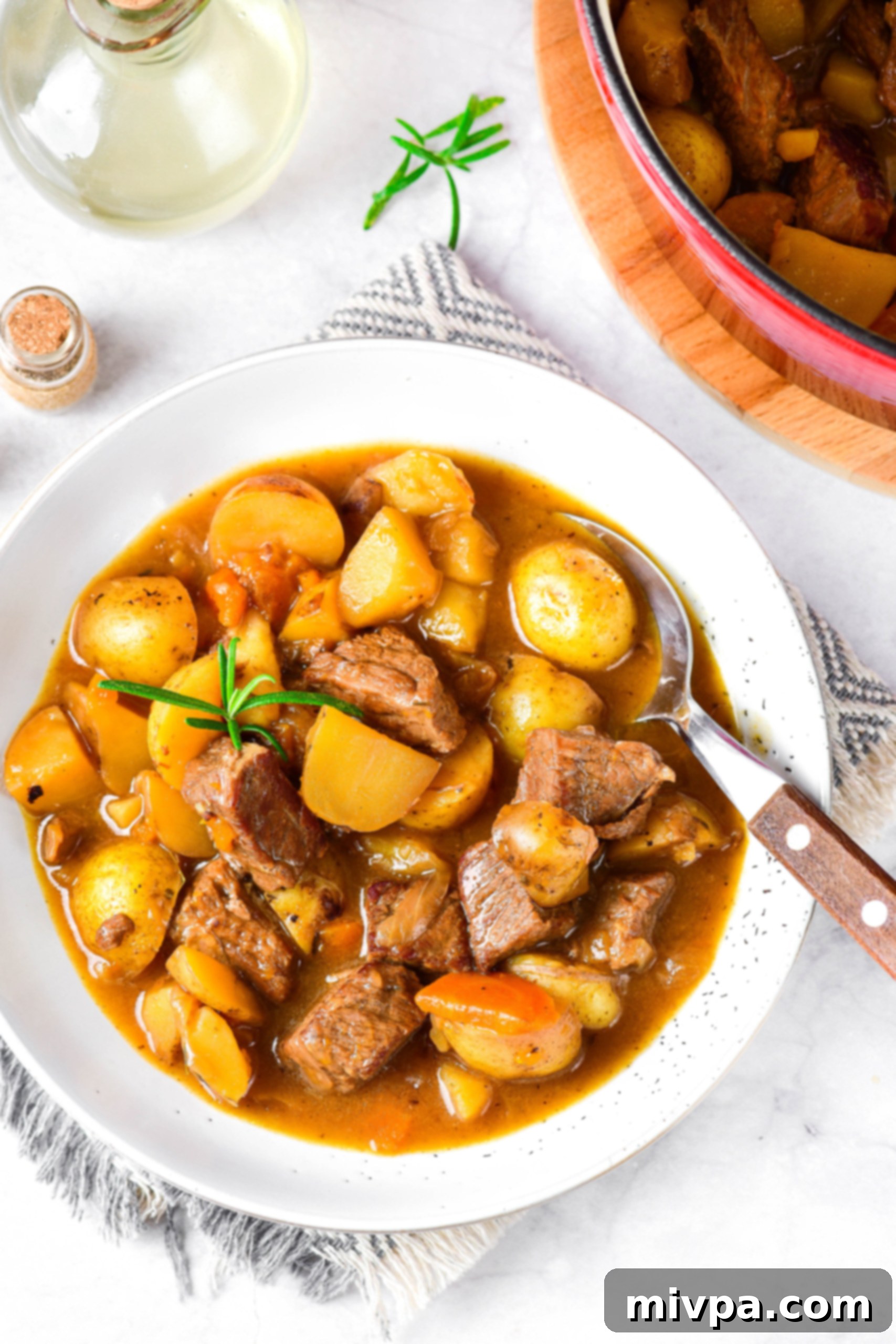 Gluten Free Dairy-Free Beef Stew Recipe Top down view of a bowl of gluten-free beef stew on white board.