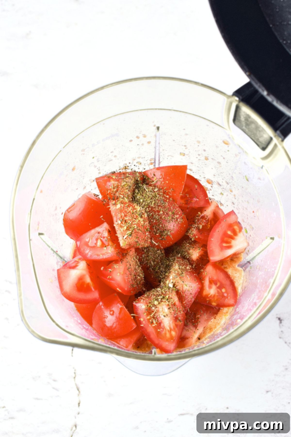 Chopped tomatoes in a blender, ready to be processed into gazpacho.