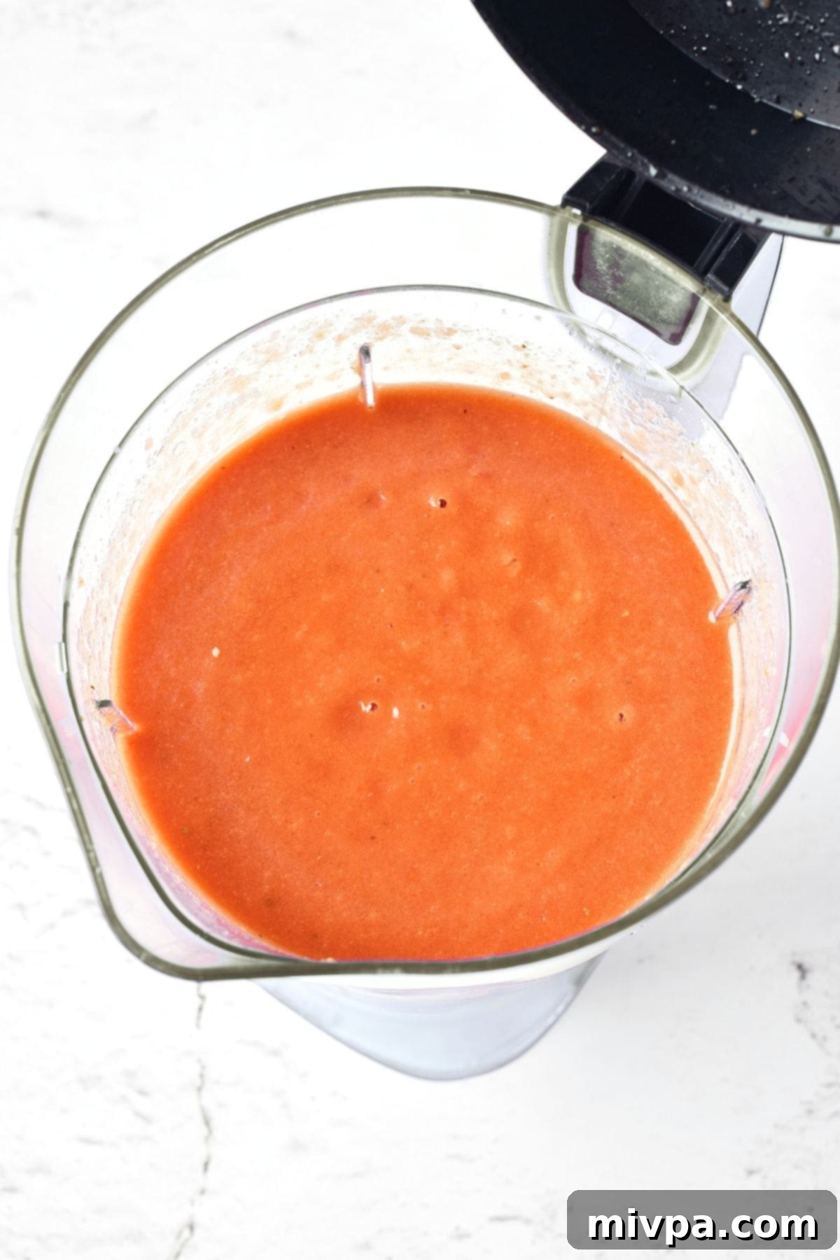 Smooth, blended gazpacho swirling in a blender, ready for its final chill.