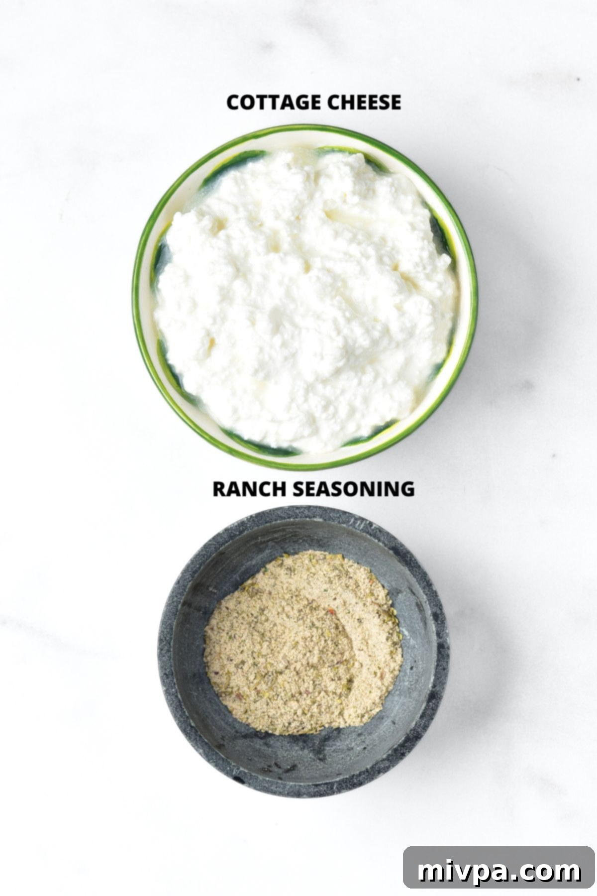 Cottage Cheese Ranch Dip Recipe (Gluten-Free) Ingredients for 2-ingredient cottage cheese ranch dip recipe laid out on marble board, showing cottage cheese and ranch seasoning mix.