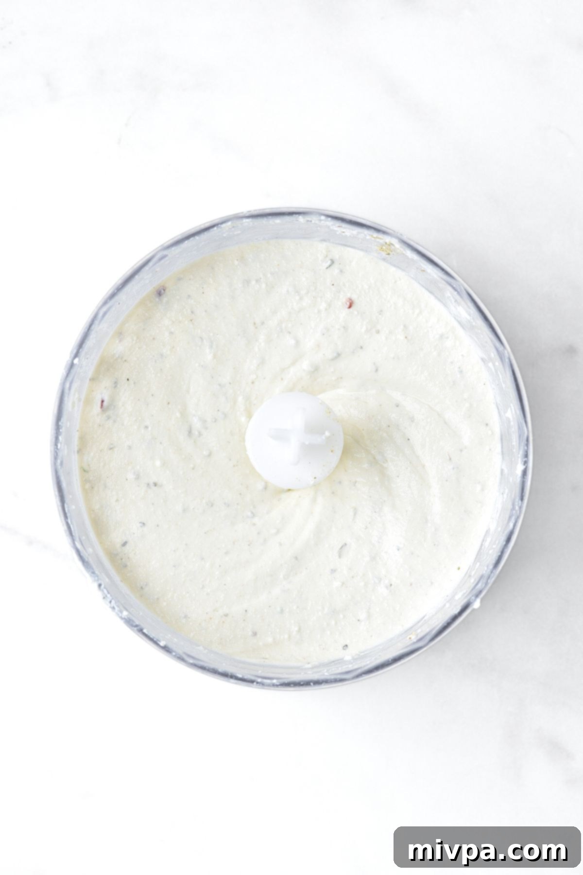 Cottage Cheese Ranch Dip Recipe (Gluten-Free) Processed cottage cheese ranch dip in food processor bowl, showing a smooth and creamy texture.
