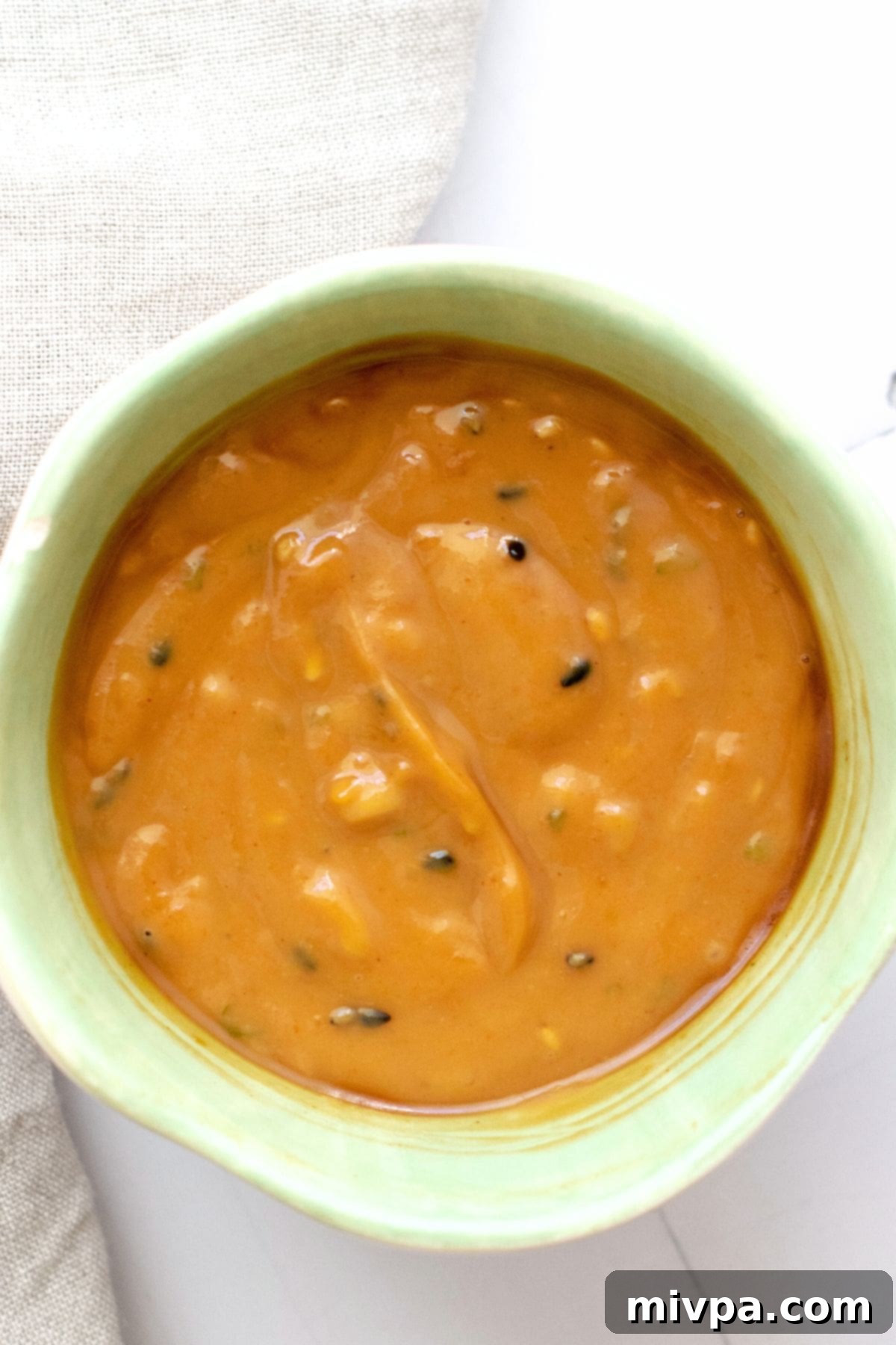 A bowl of peanut sauce topped with sesame seeds
