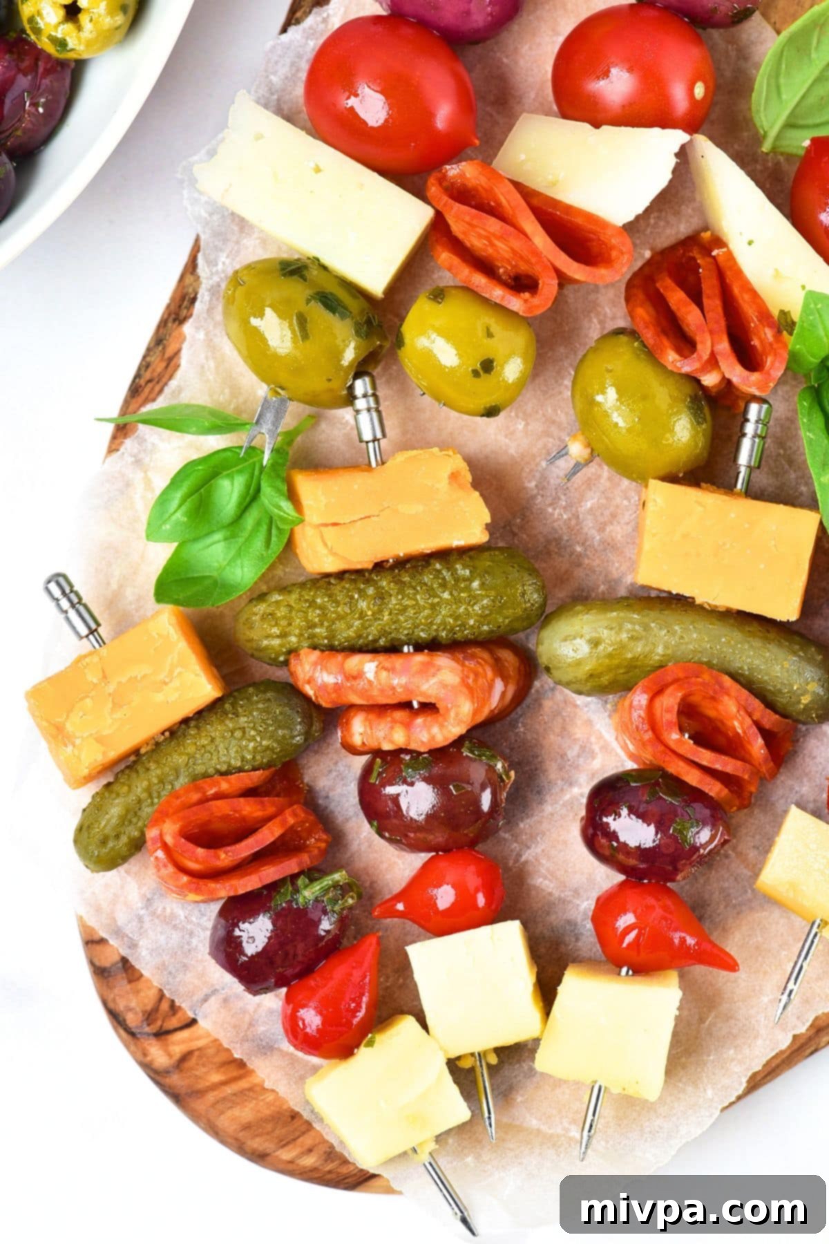 Top down view of charcuterie board skewers on wooden board.
