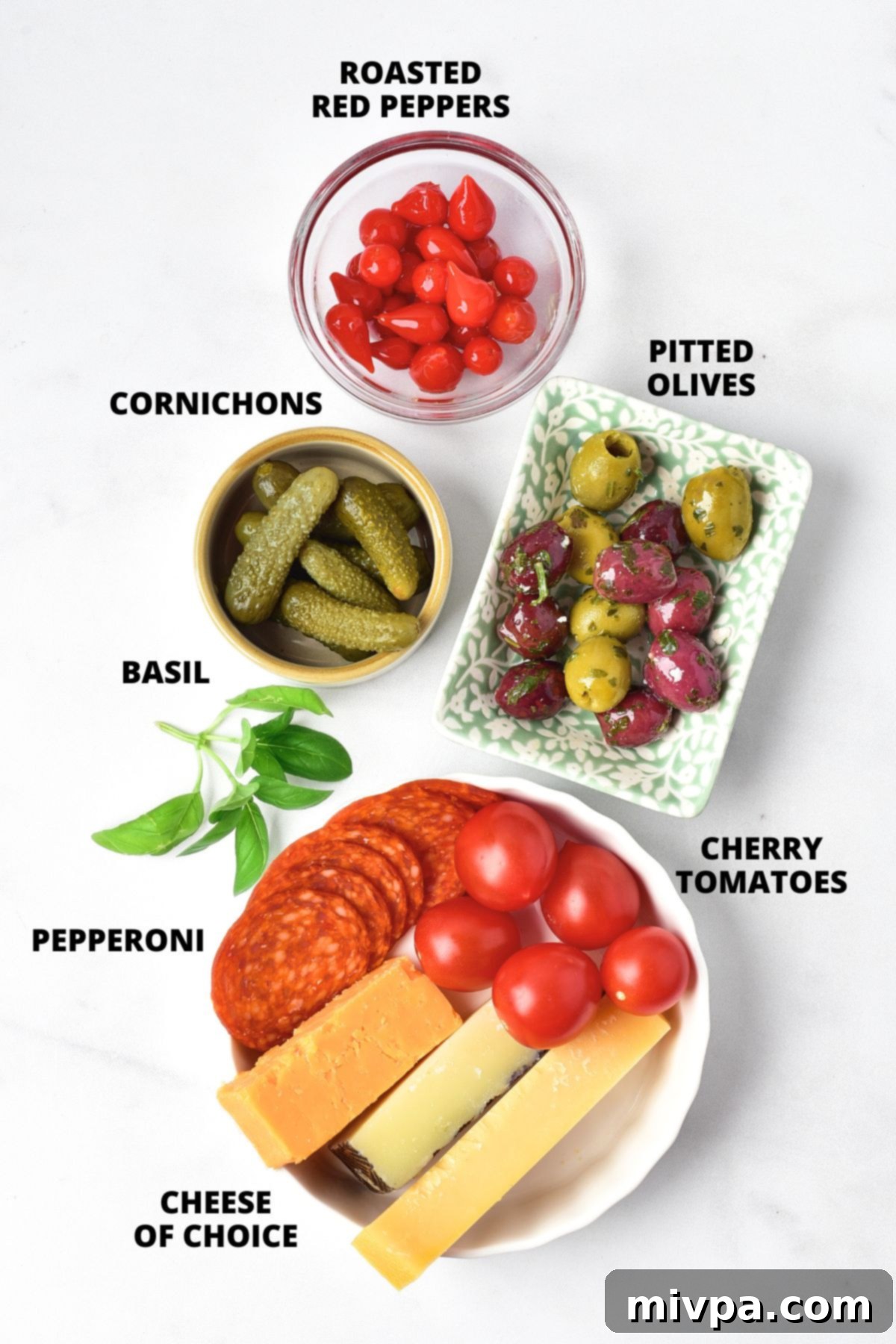 Ingredients for charcuterie skewers recipe laid out on marble board.