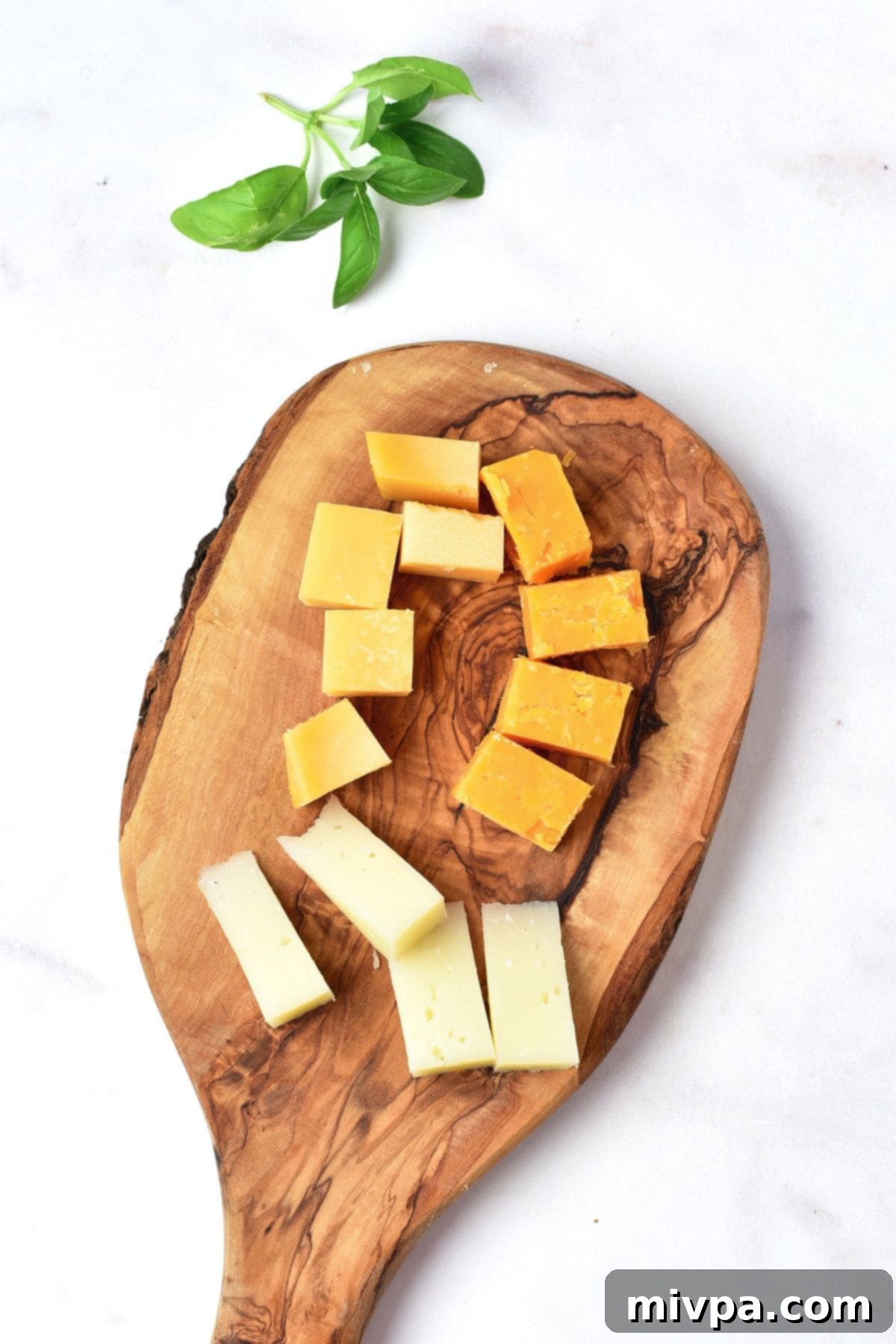 Cheese cubes on wooden board.