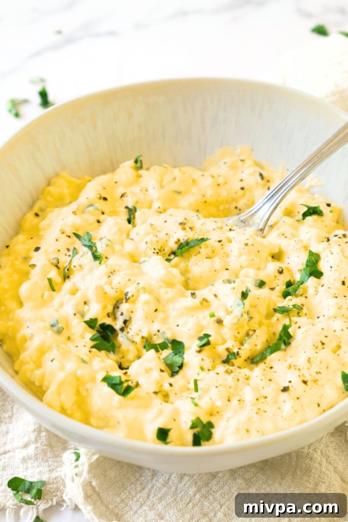 Scooping a spoonful of gluten-free egg salad from a bowl.