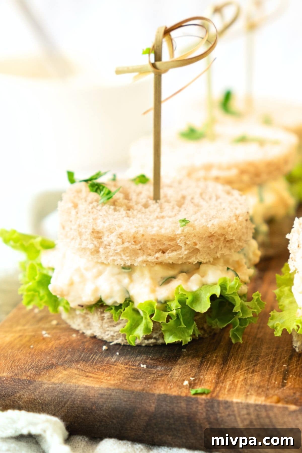 Dairy-free egg salad sandwiches on wooden board.