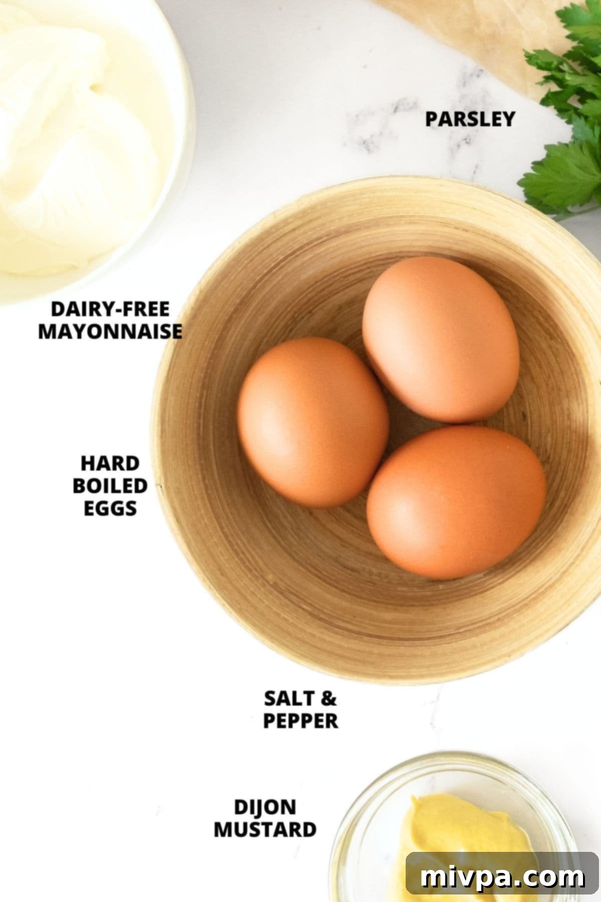 Ingredients for gluten-free egg salad recipe laid on marble board.