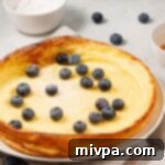 Your Go-To Gluten-Free Dairy-Free Dutch Baby 2 Dutch baby topped with fresh blueberries and powdered sugar.